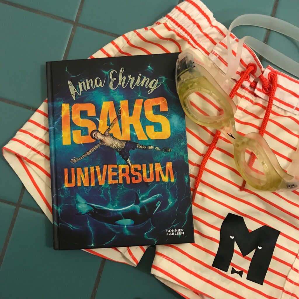 Barnboken "Isaks universum" av Anna Ehring tillsammans med badshorts från Mini Rodini. 